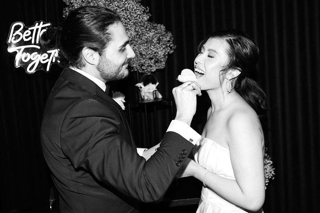 Brautpaar vom Paris-Luxus-Hochzeitskonzept am Kuchen essen in schwarz-weiß